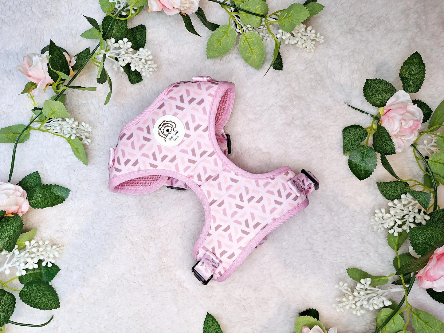 A pink dog harness with a geometric design