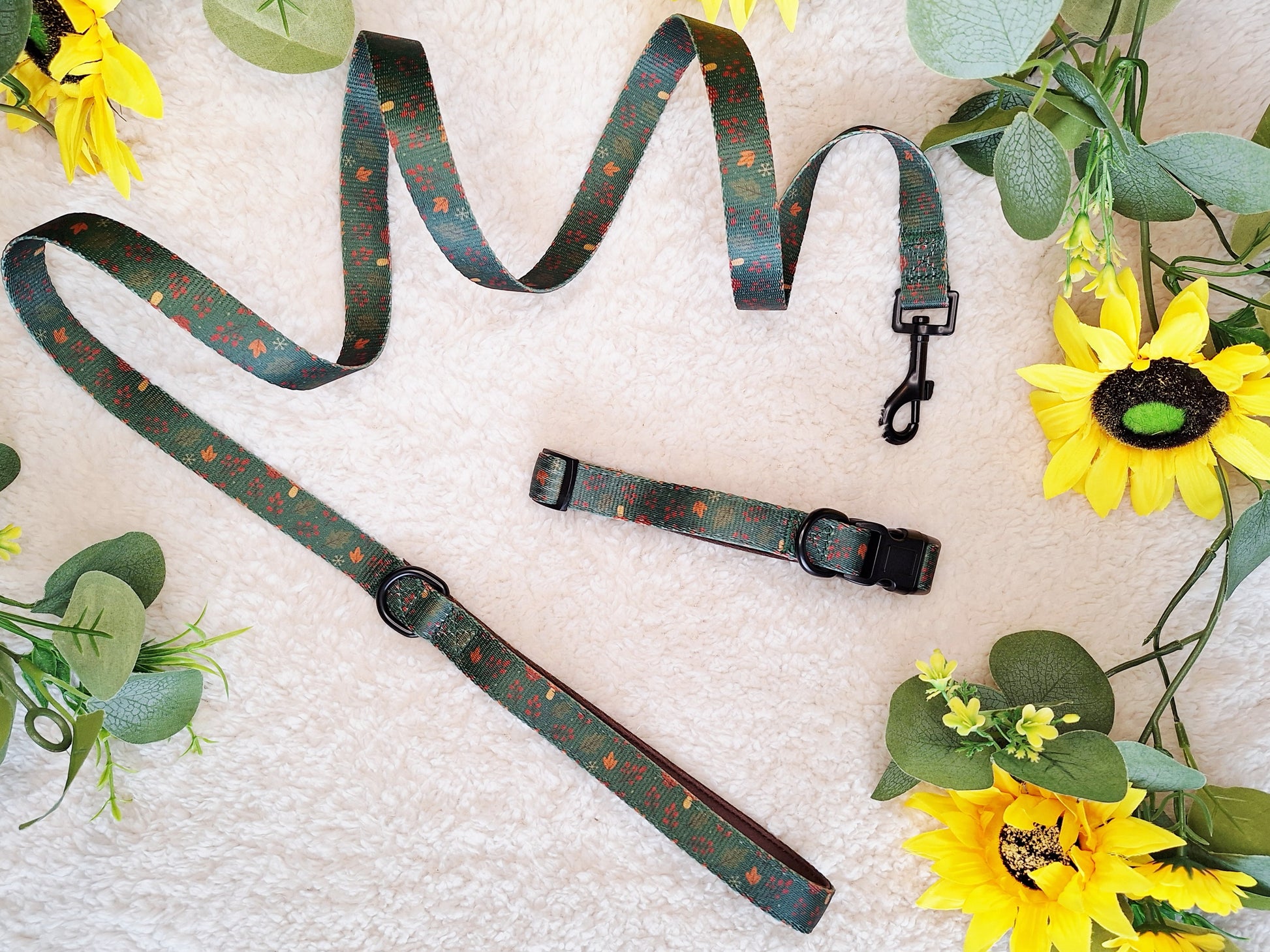 Green floral dog leas with a matching dog collar, laid on a white background surrounded by sunflowers