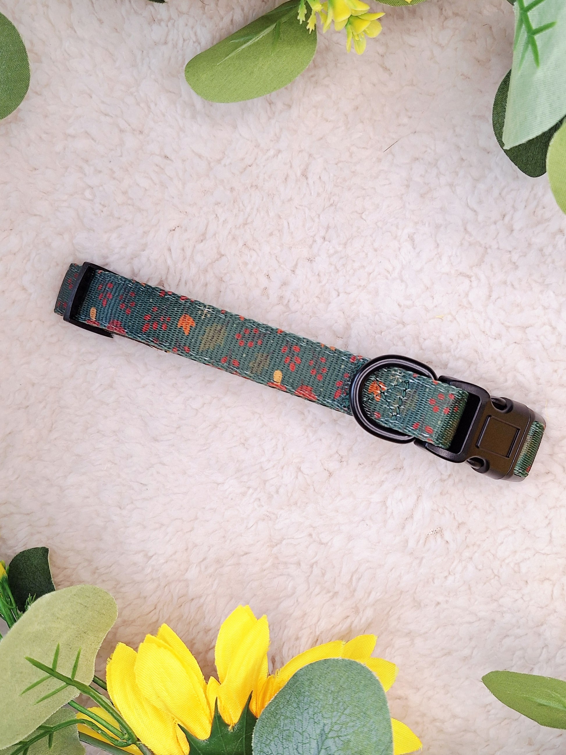 Dog collar with floral pattern on a textured surface with flowers and leaves.