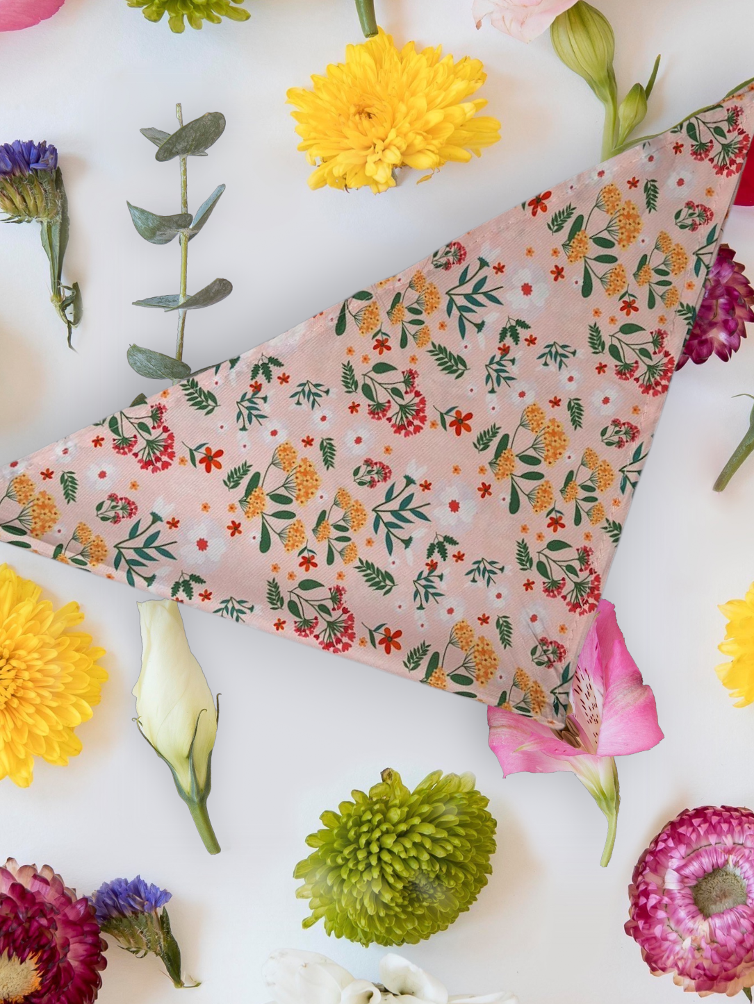 Floral design Dog bandana laid out with flowers around it