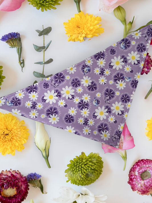 Purple Dog bandana with daisy design, laid out with flowers